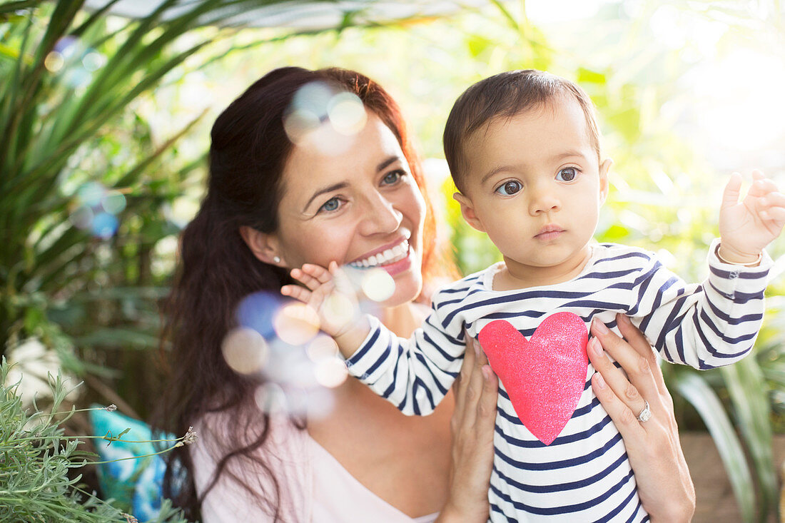 Mother holding baby girl outdoors