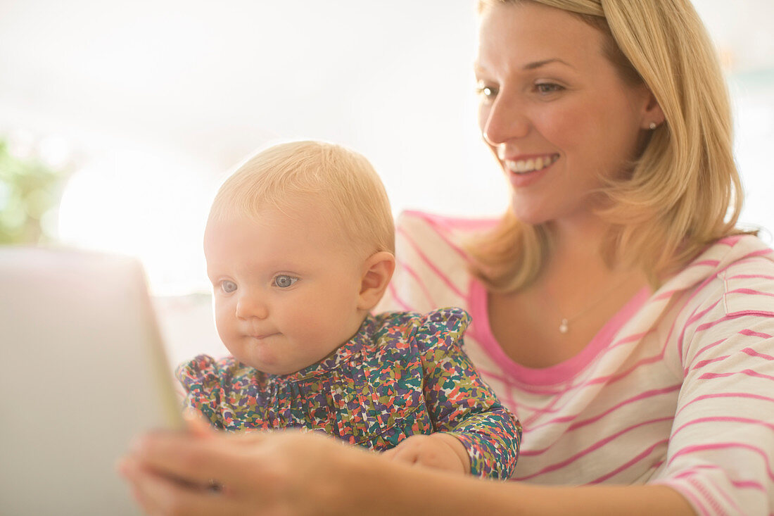 Mother and baby girl using digital tablet