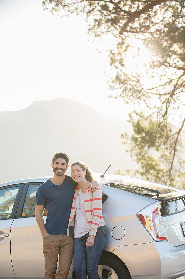 Portrait of happy couple outside car