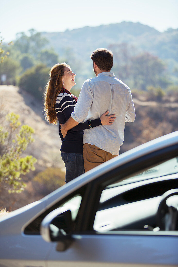 Happy couple hugging at roadside