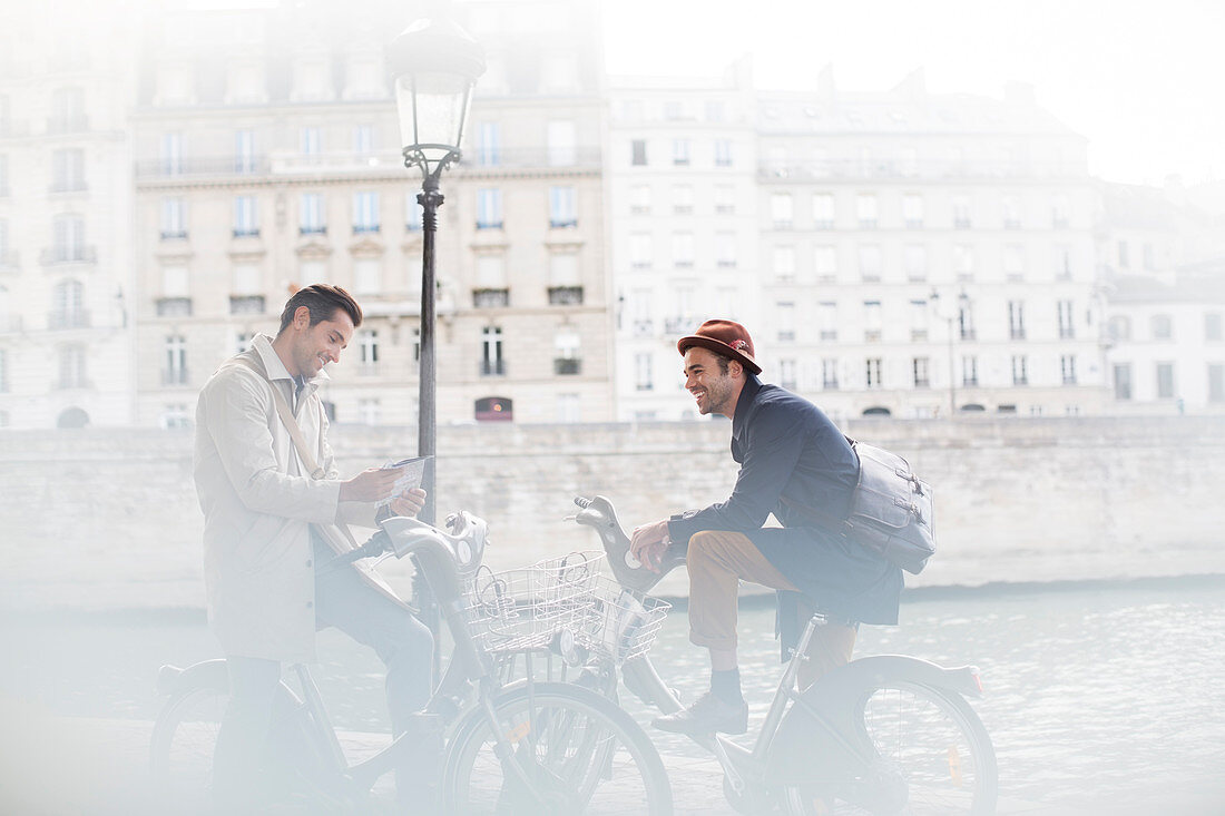 Businessmen talking on bicycles