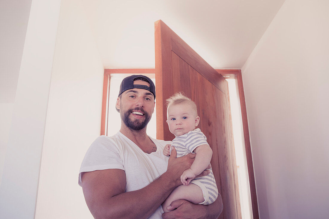 Smiling father holding baby son