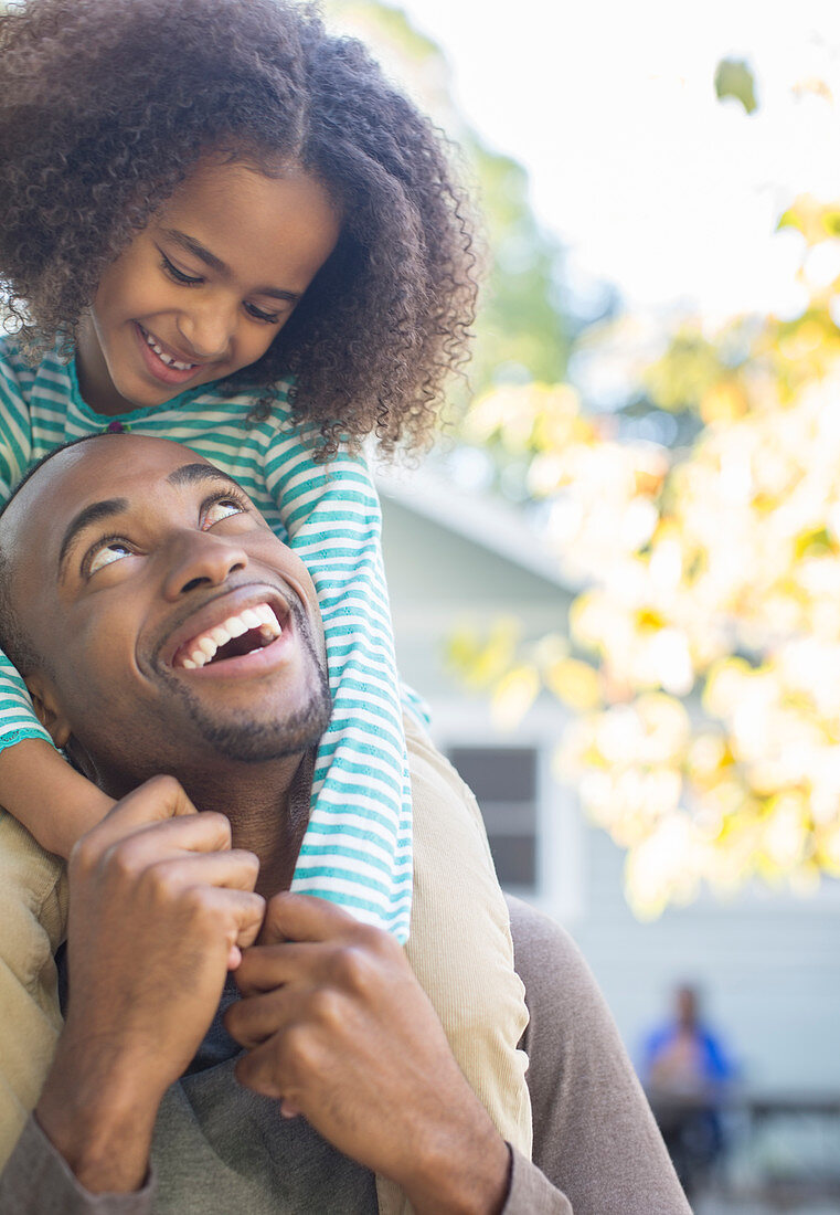 Father carrying daughter on shoulders