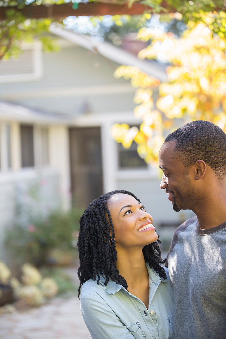 Happy couple hugging outside house