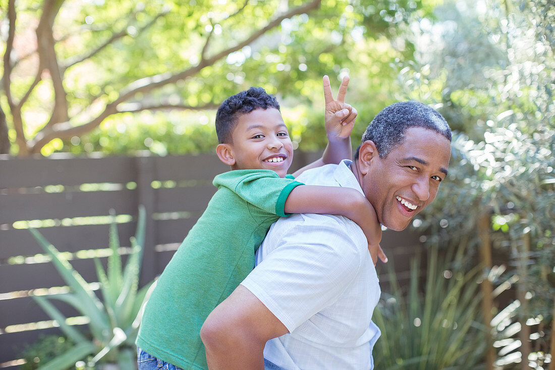 Happy grandfather piggybacking grandson