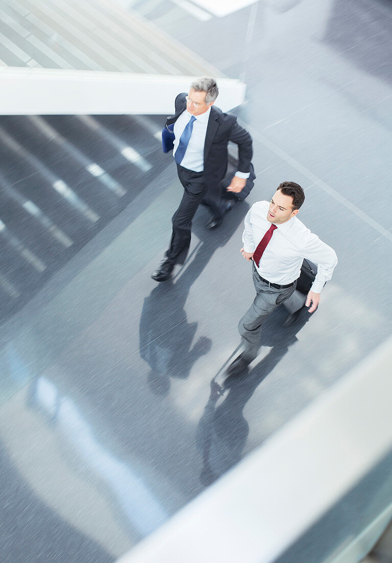 Businessmen with suitcases running