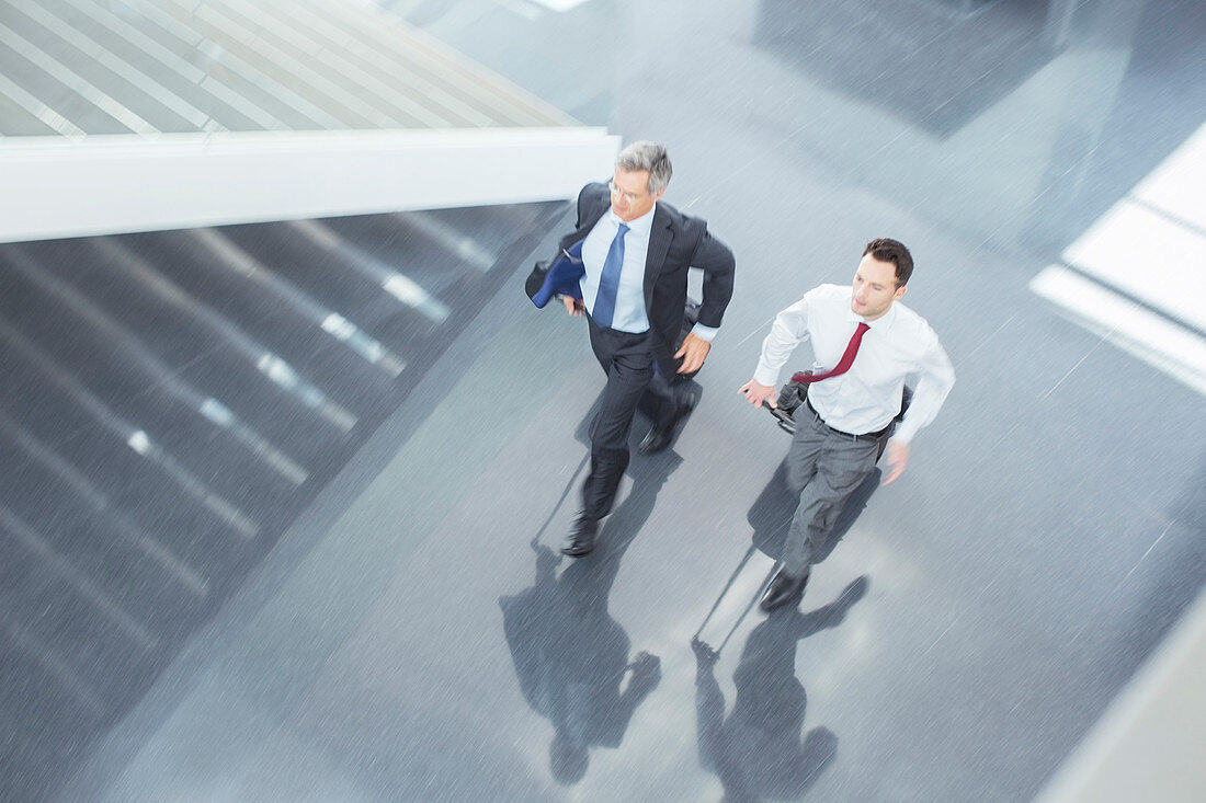 Businessmen with suitcases running