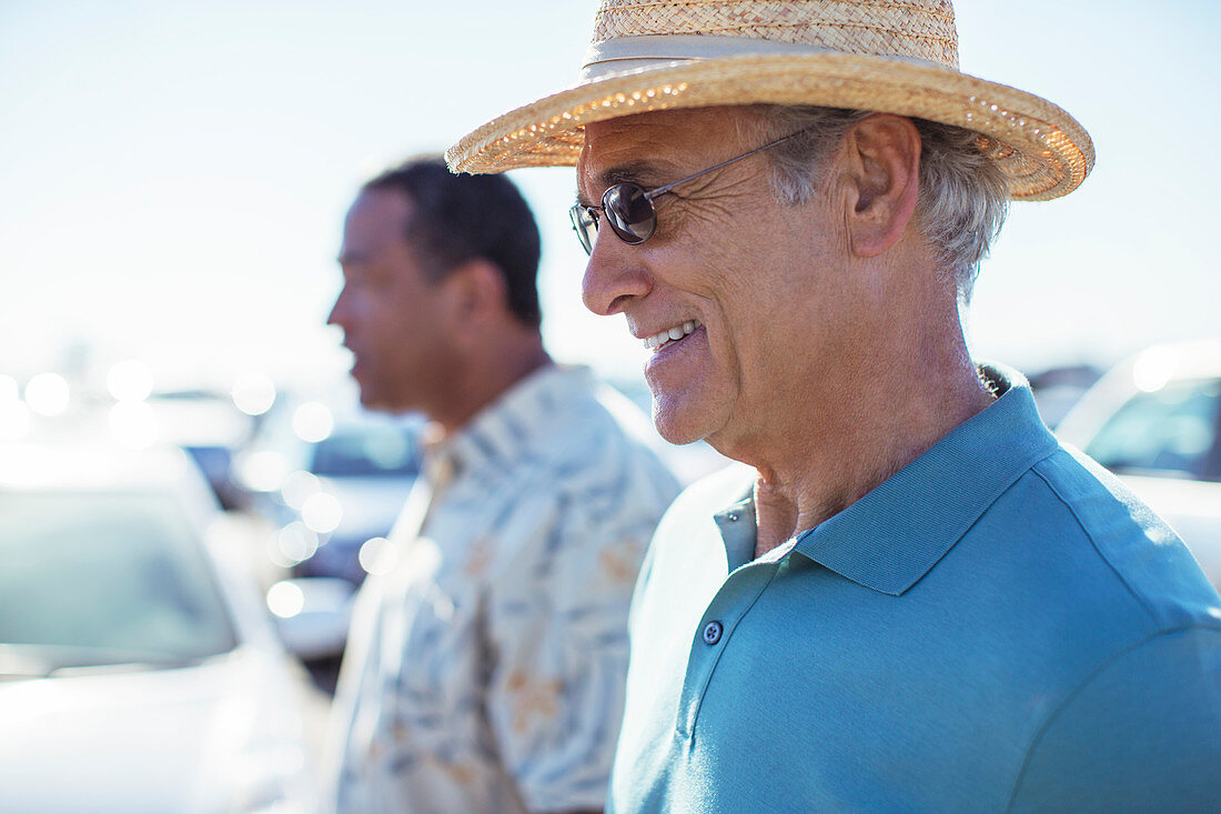 Senior men in sunny parking lot