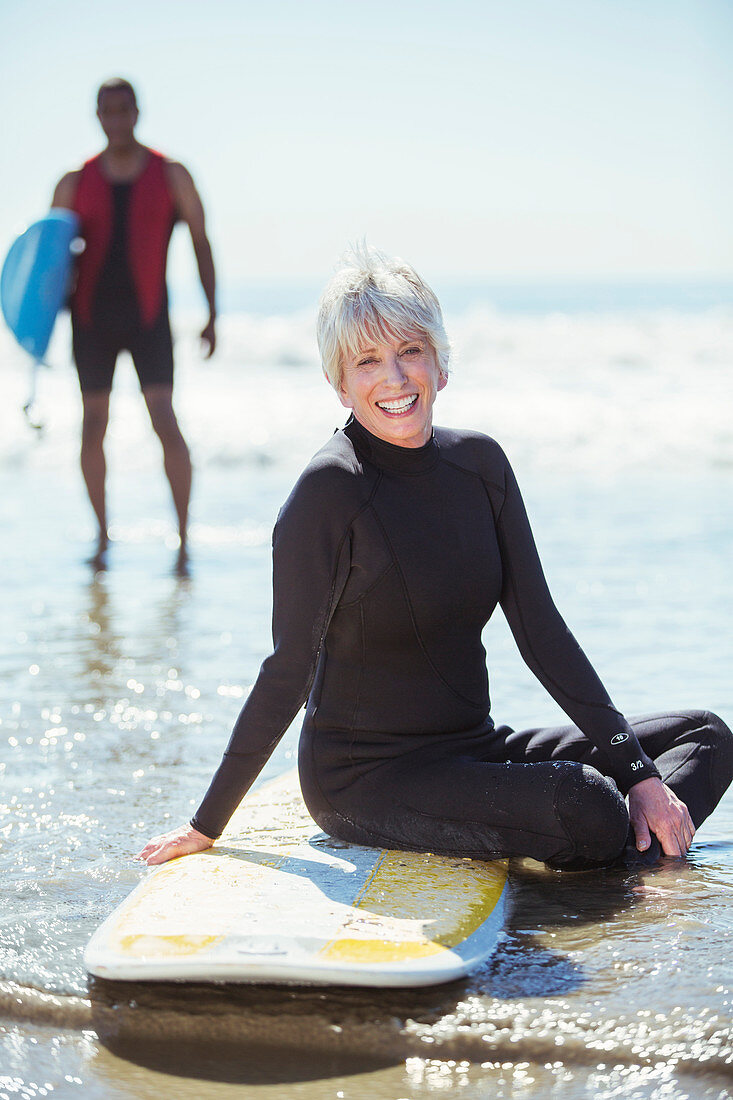 Senior woman on surfboard at beach