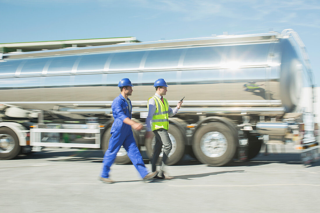 Businessman and worker walking on tanker