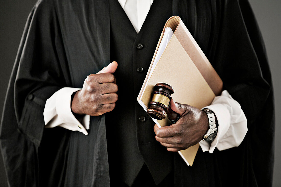 Close up of judge holding file and gavel
