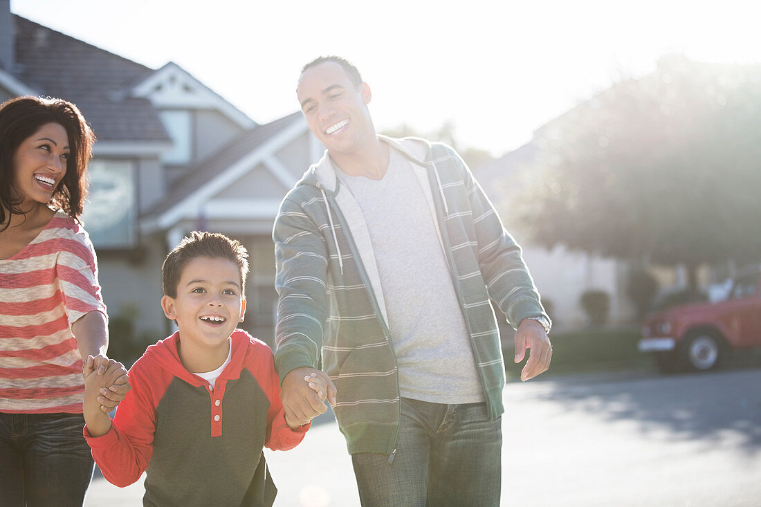 Happy family running on sunny street