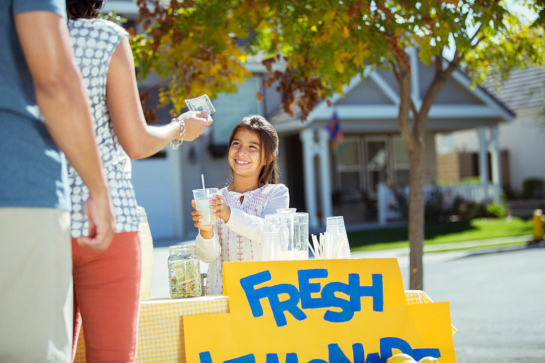 Girl selling lemonade at lemonade stand