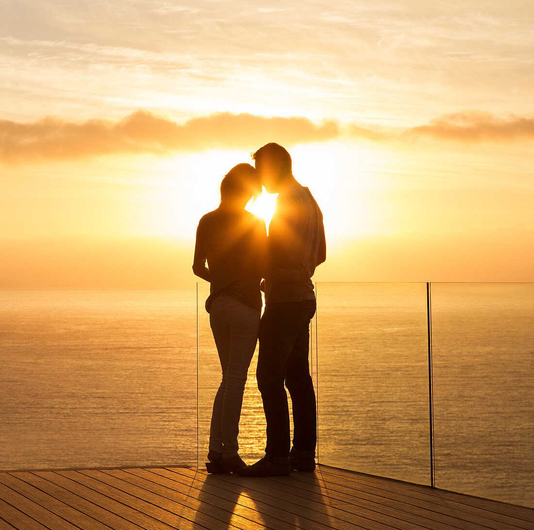 Silhouette of couple at sunset over ocean