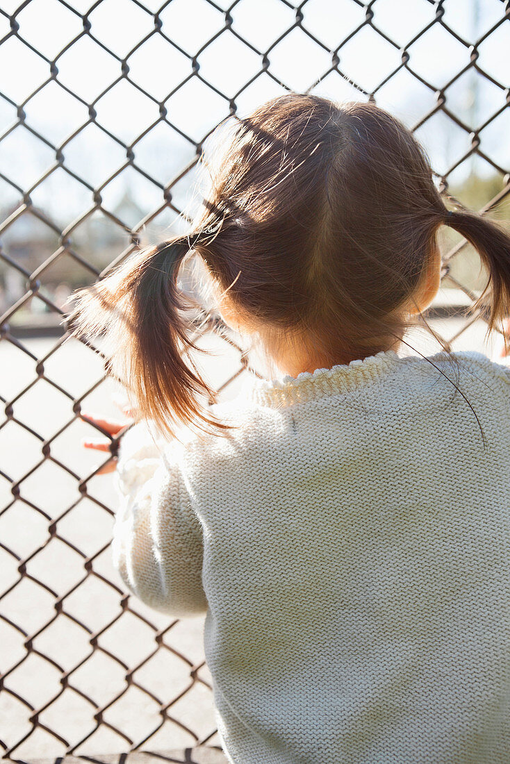 Girl standing at chain link fence