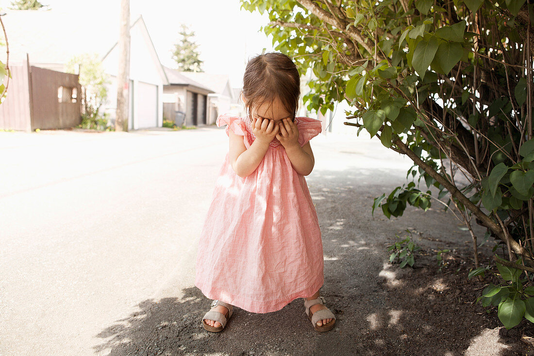 Girl covering her face outdoors