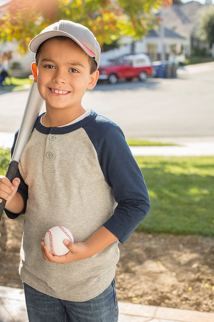 Smiling boy with baseball and bat