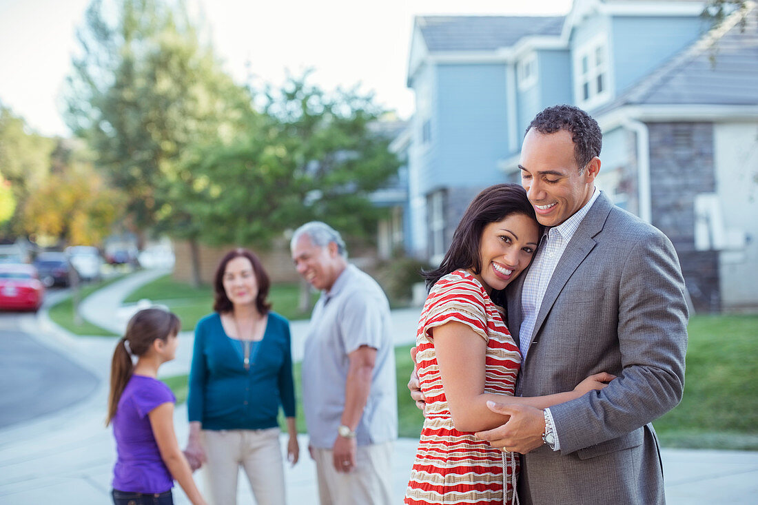 Happy couple hugging in driveway