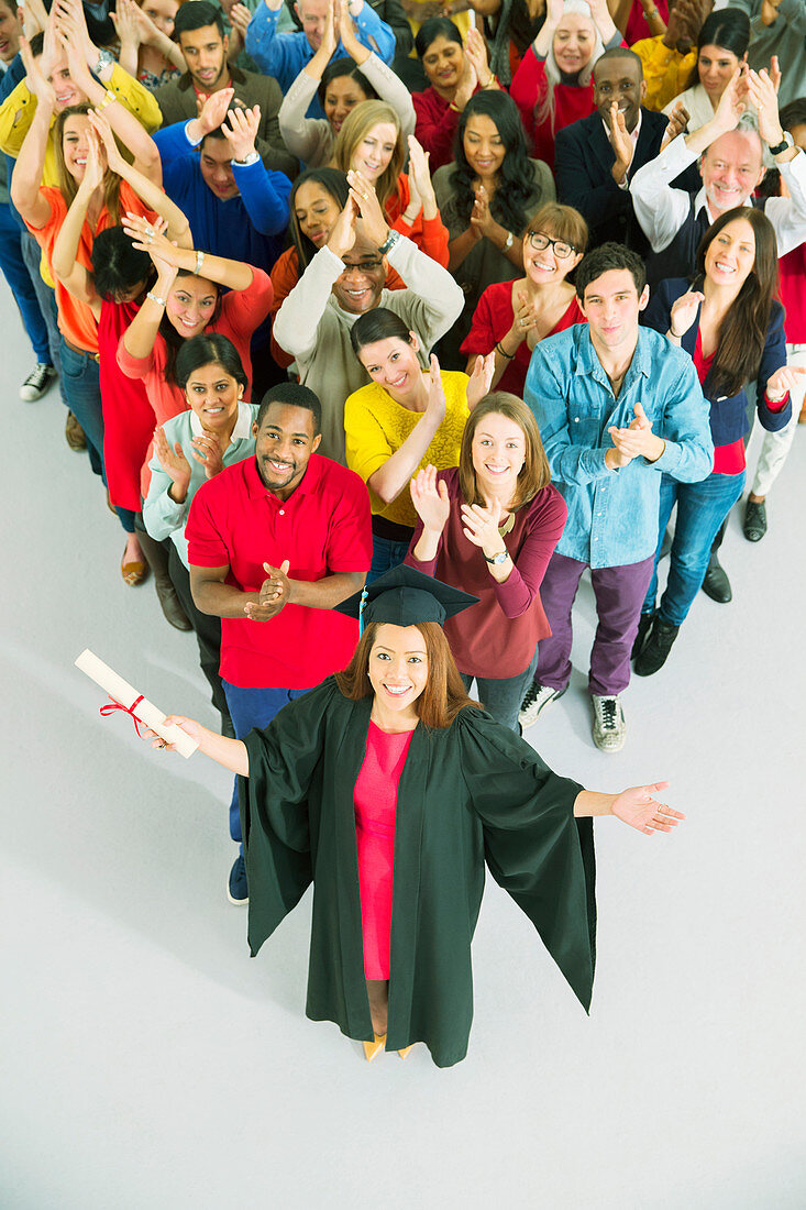 Clapping crowd behind graduate