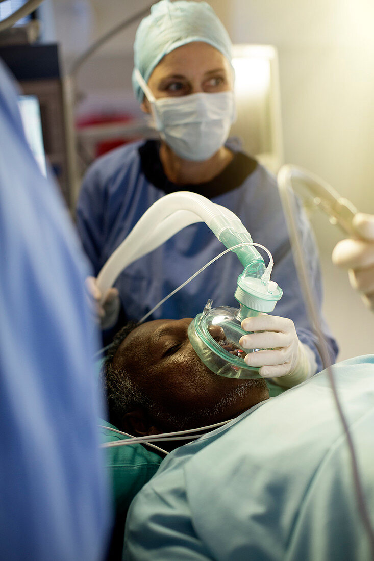 Anaesthesiologist holding oxygen mask