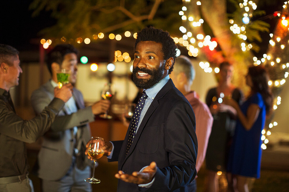 Man gesturing with wine at party