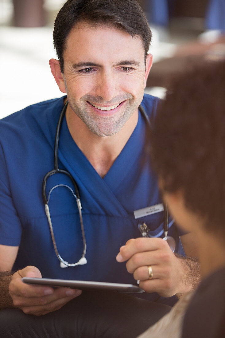 Smiling mid adult doctor holding tablet