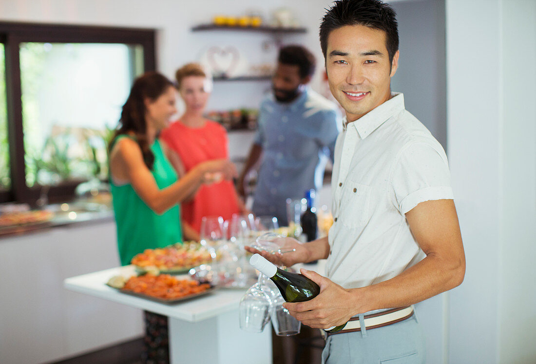 Man carrying bottle of wine at party