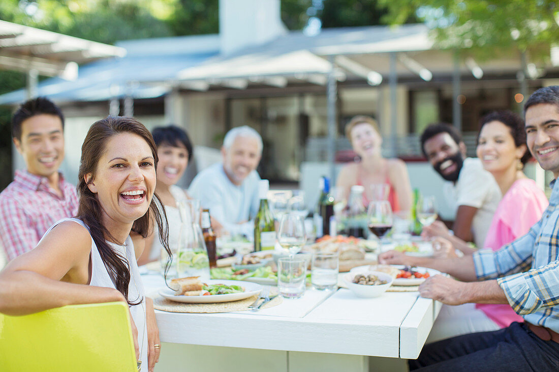 Friends smiling at table outdoors