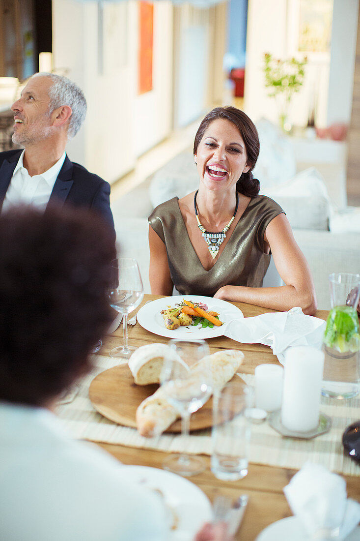 Woman laughing at dinner party