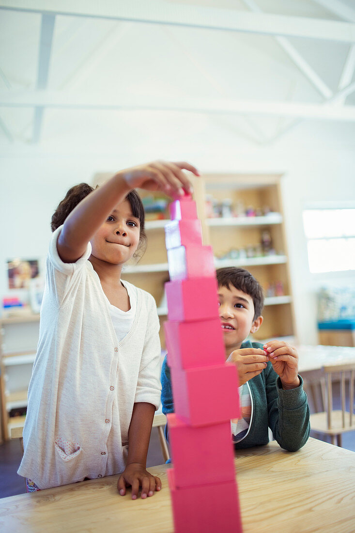 Students stacking blocks in classroom