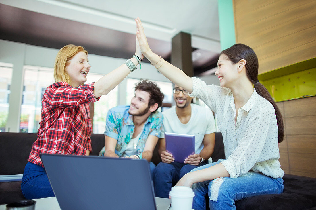 People high fiving in office