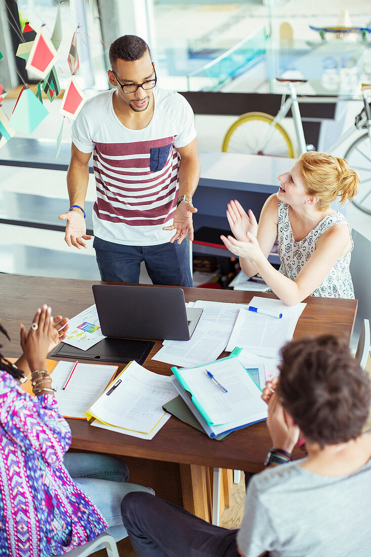 People applauding colleague in office