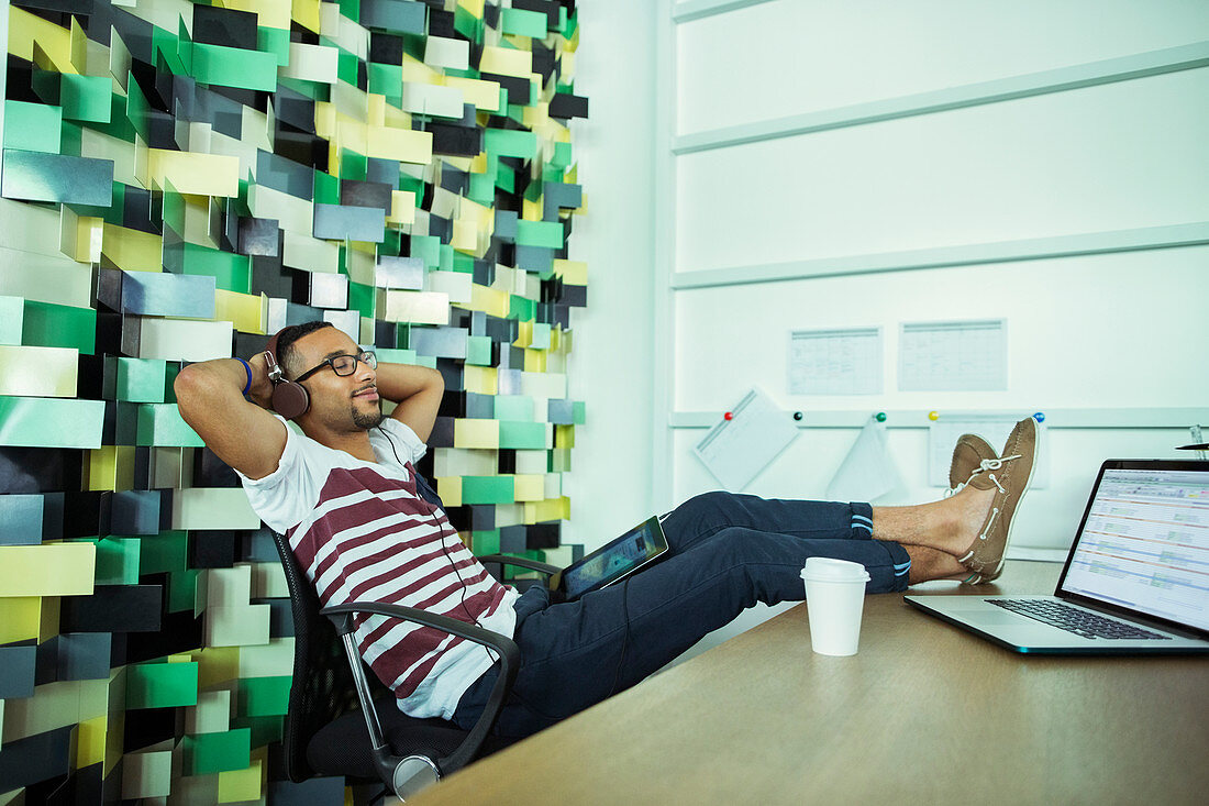 Man relaxing at desk in office