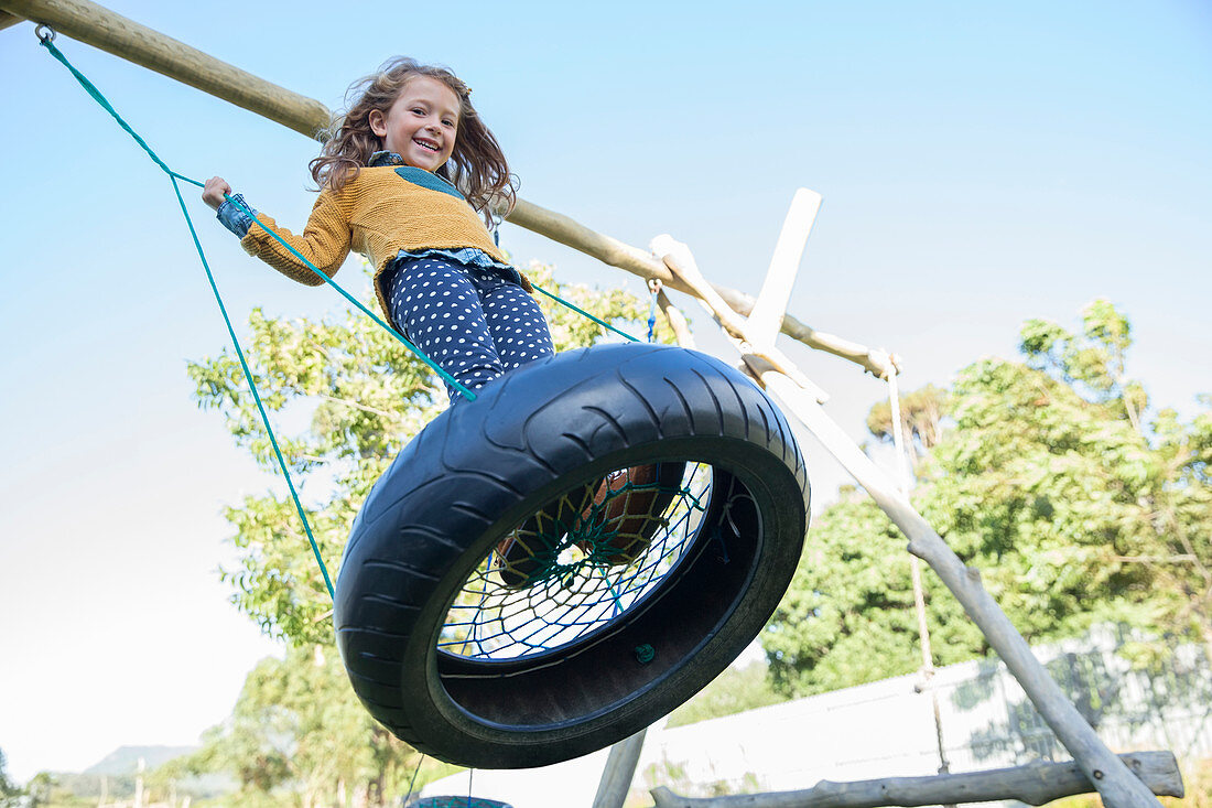 Girl playing on tire swing