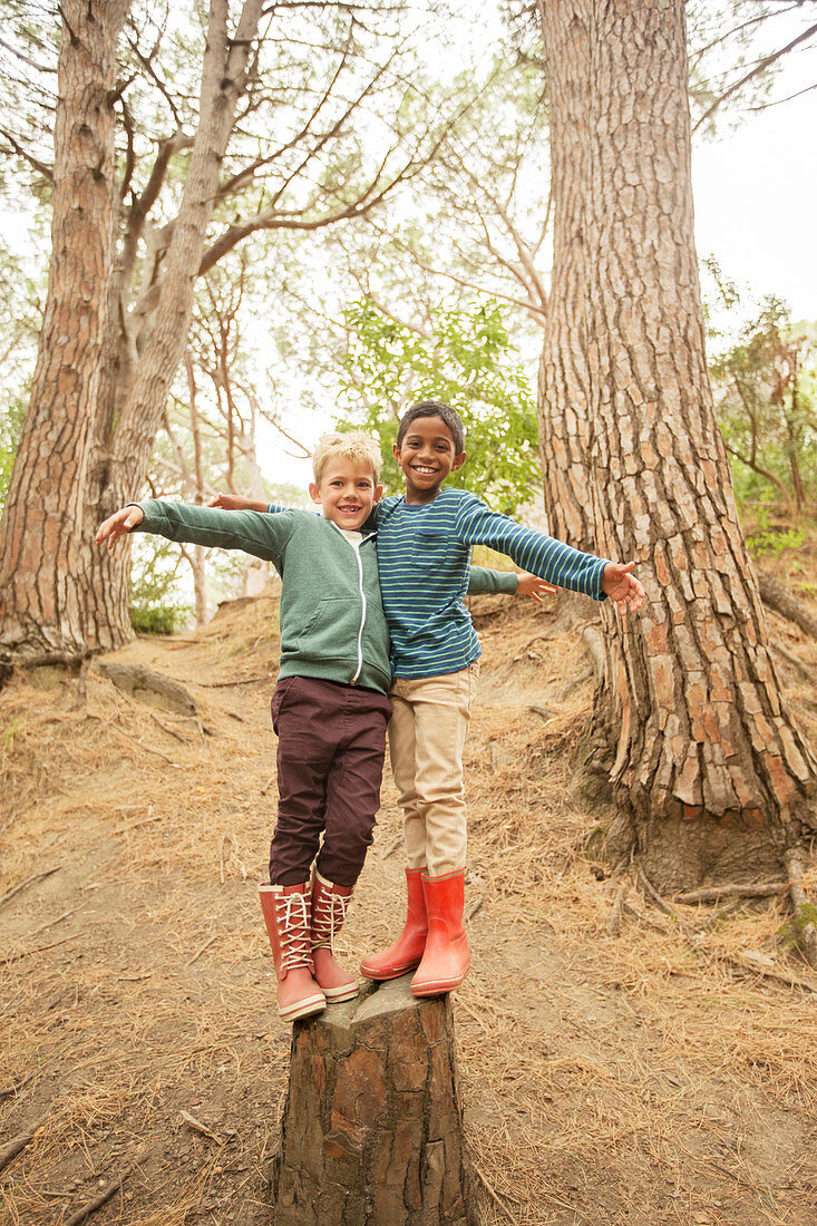 Children climbing on stump in forest