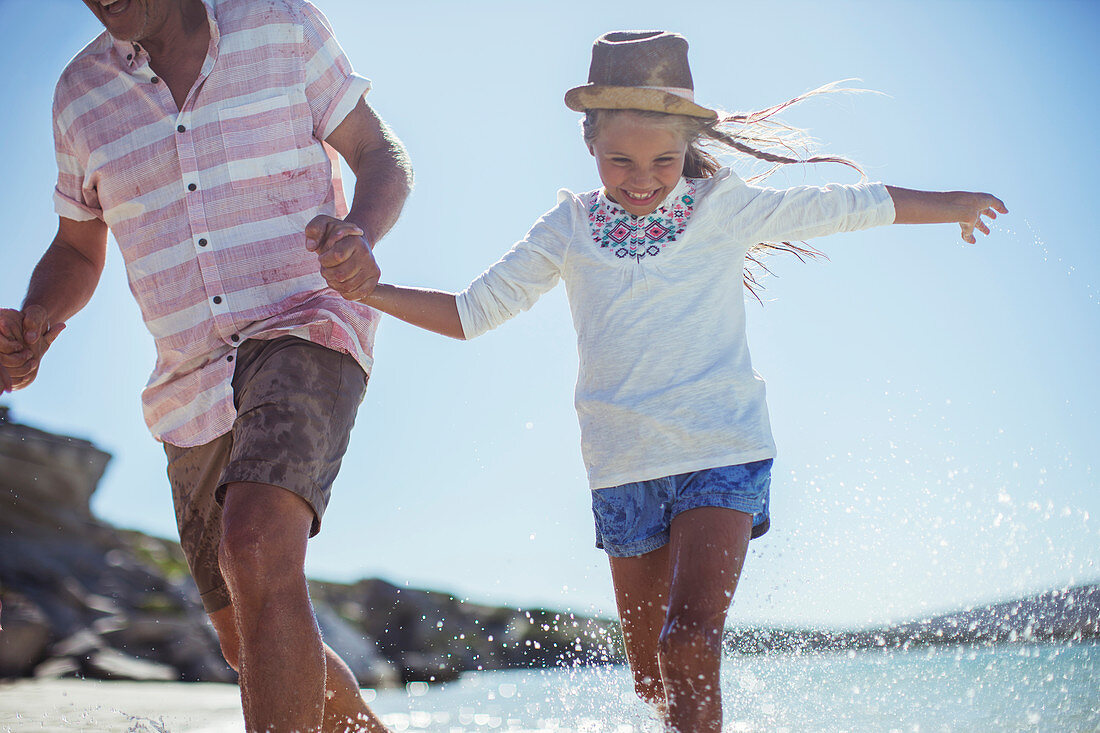 Family running in water on beach