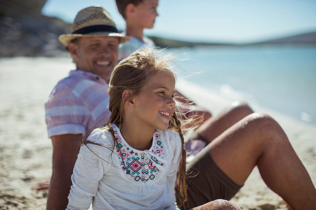 Young girl sitting with family on shore