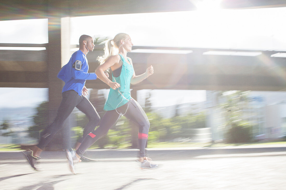 Couple running through city streets