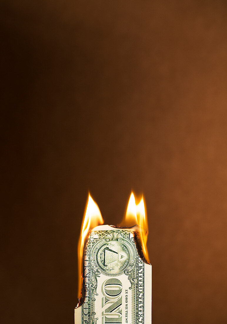 Folded dollar bill burning