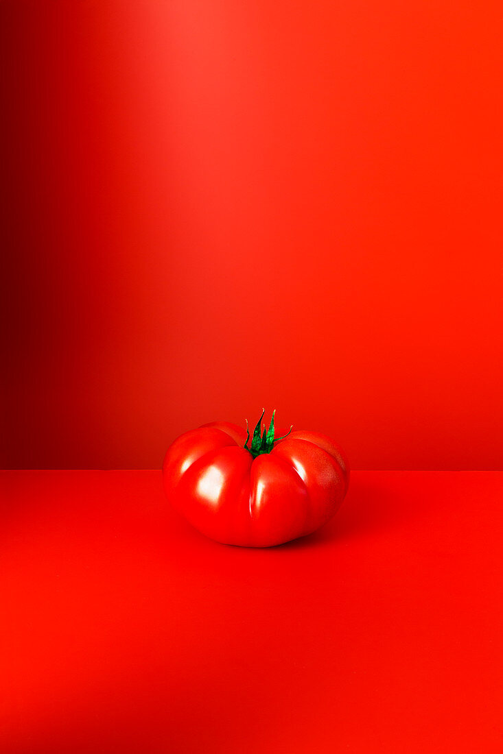 Tomato sitting on red counter