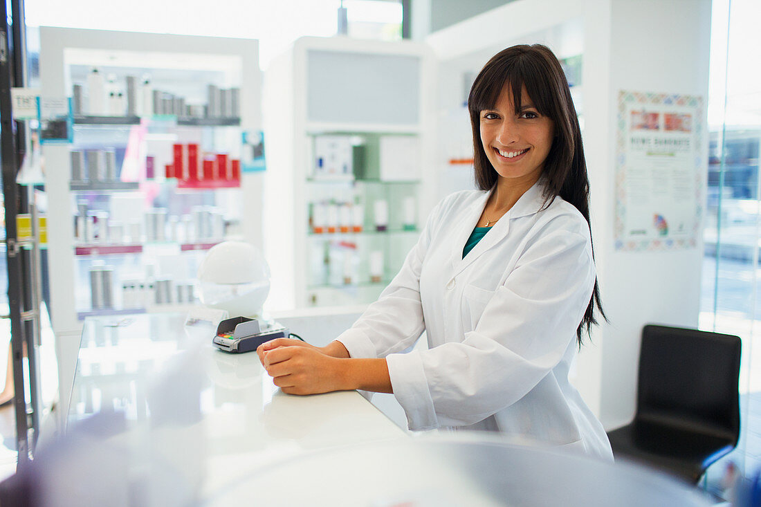 Pharmacist smiling behind counter