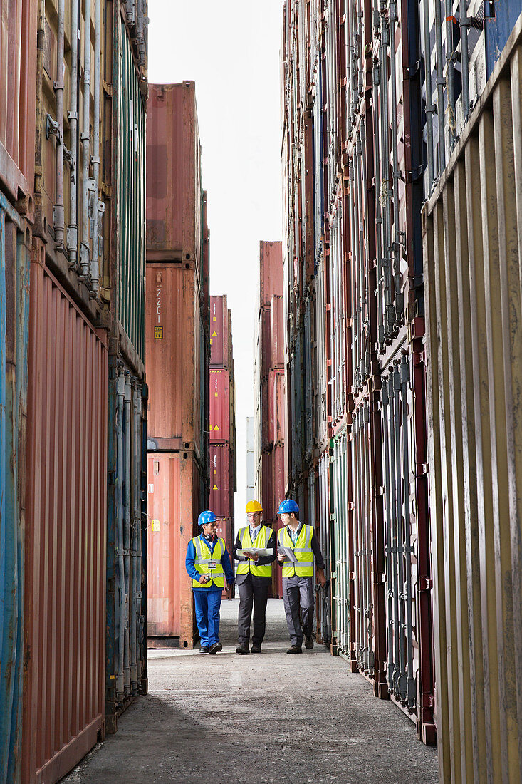 Workers talking between cargo containers