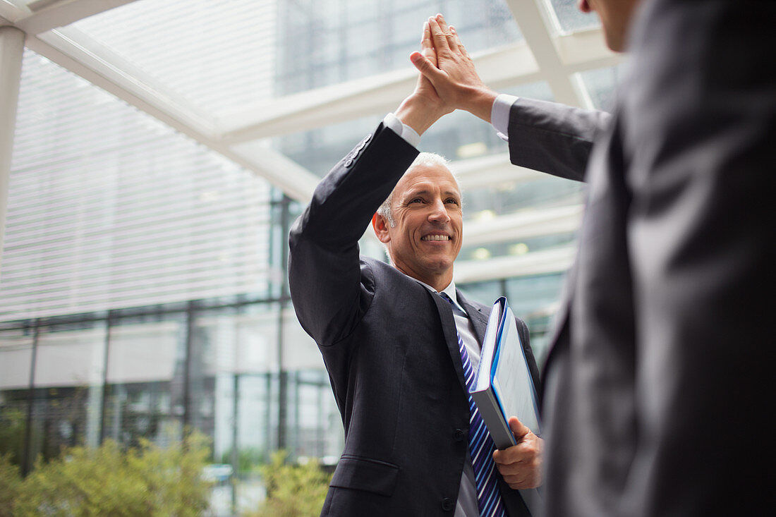 Businessmen high fiving