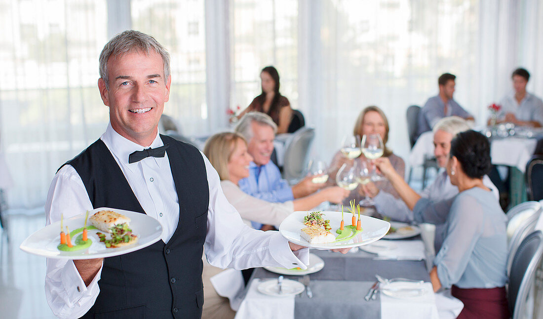 Portrait of waiter holding plate