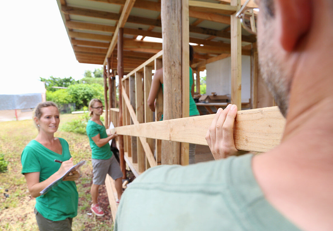 People building wooden house frame