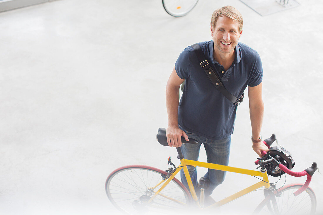 Smiling man standing with bicycle