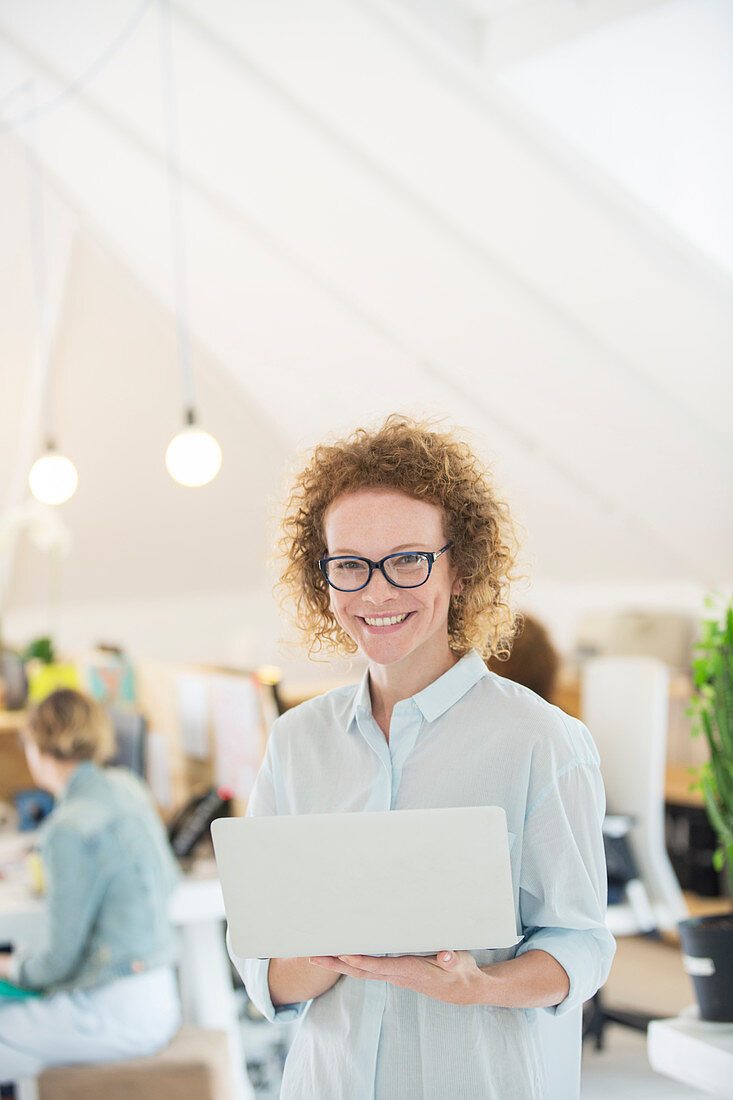 Portrait of woman holding laptop