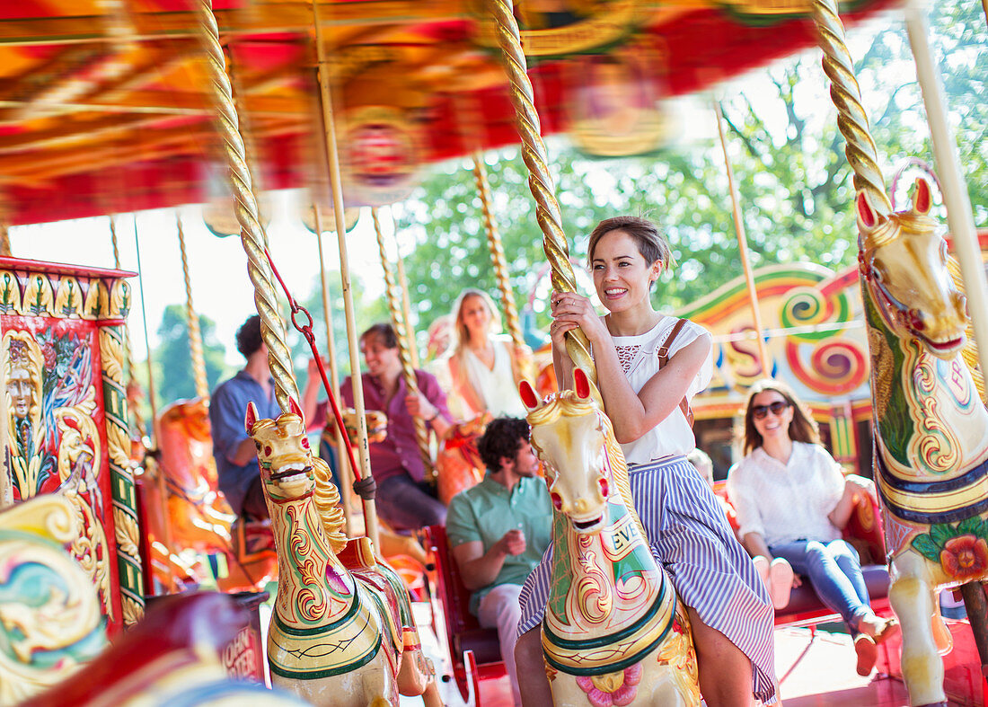 Woman sitting on horse on carousel
