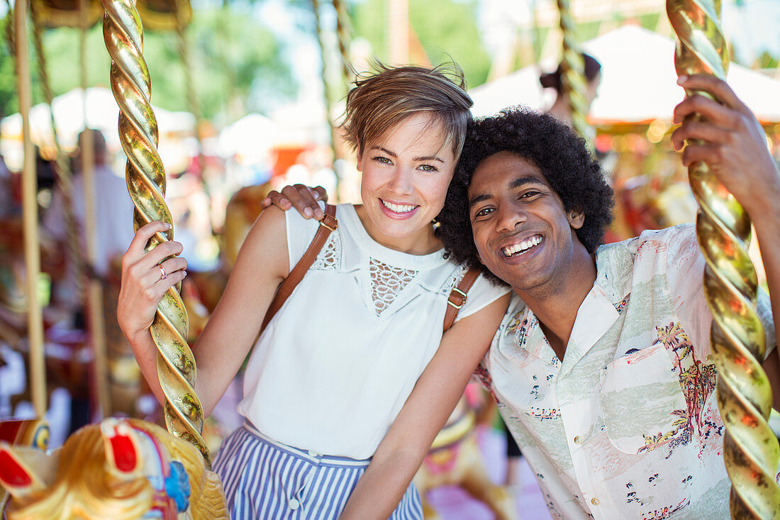 Young multiracial couple on carousel