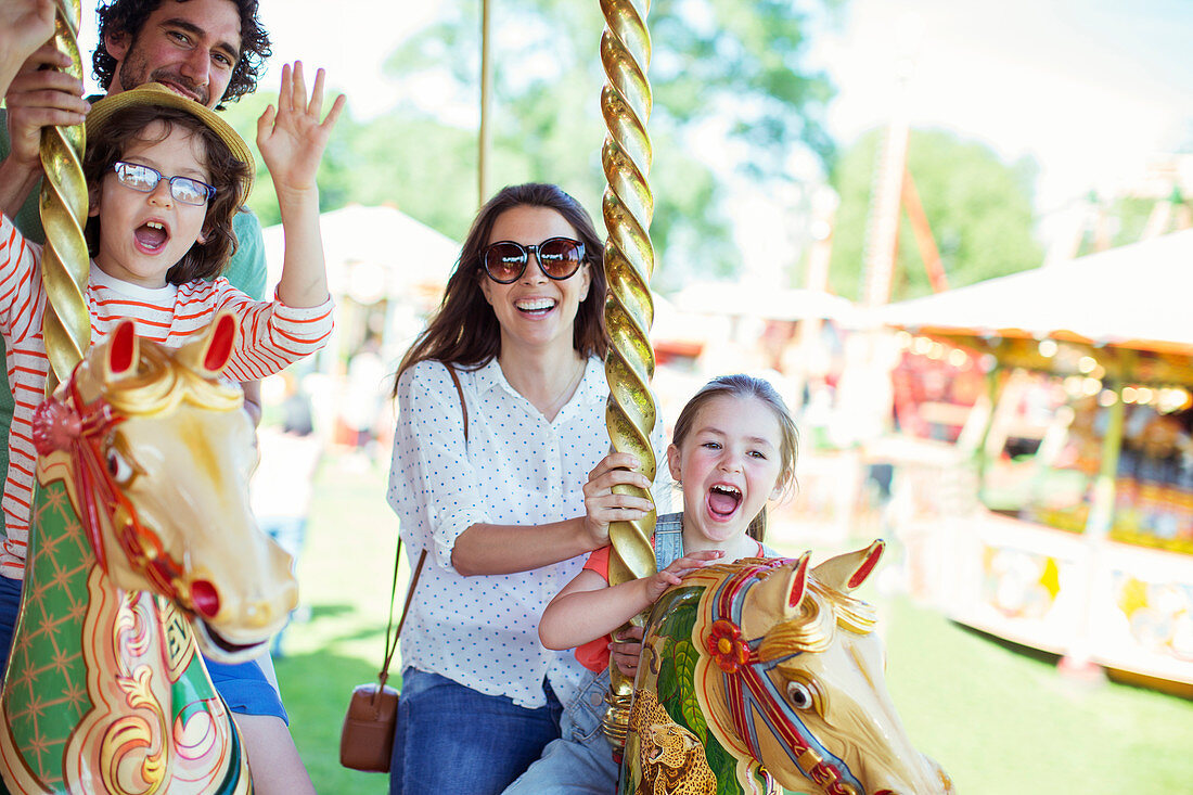 Family on carousel in amusement park